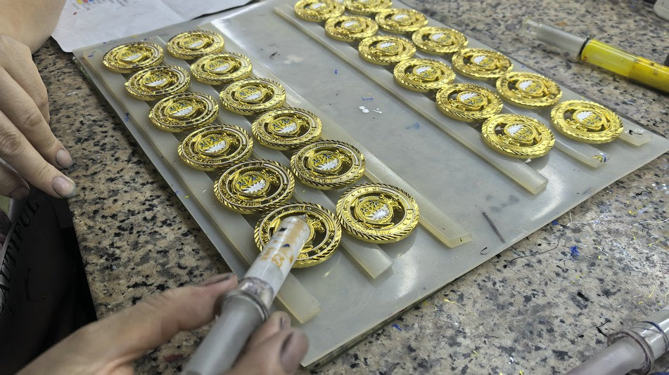 Actual production photograph showing color application to metal gifts